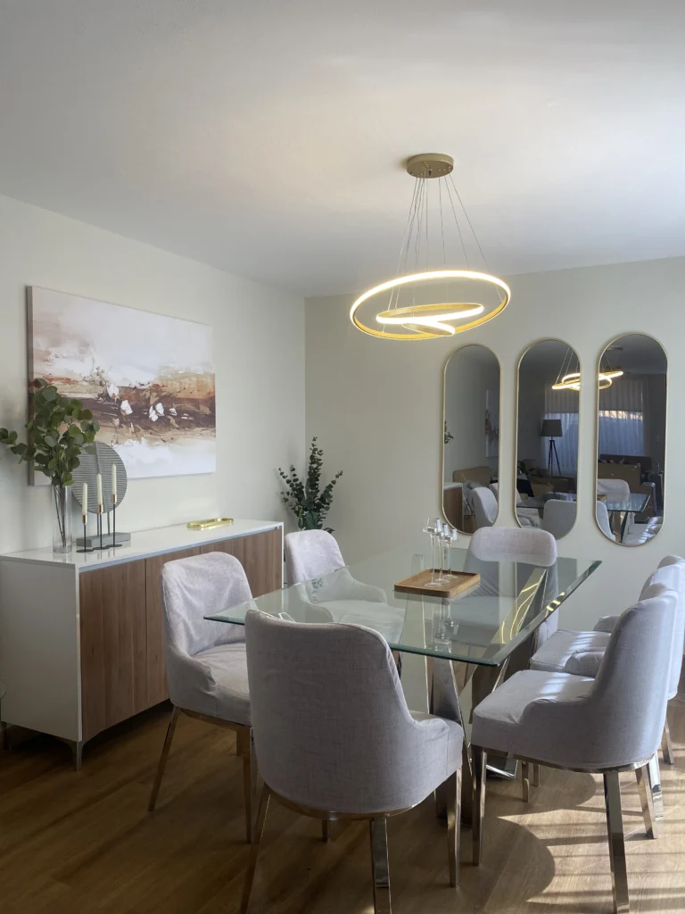 Comedor moderno con diseño de interiores contemporáneo, mesa de vidrio y luminaria colgante en Arequipa