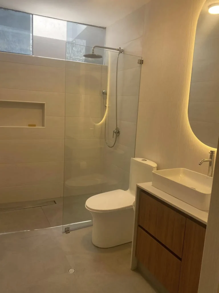 Baño moderno con diseño de interiores contemporáneo, ducha de vidrio templado y mueble de lavatorio a medida en Arequipa