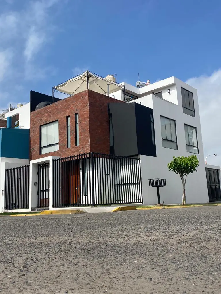 Vivienda moderna de tres niveles con diseño arquitectónico contemporáneo y fachada de ladrillo en Arequipa