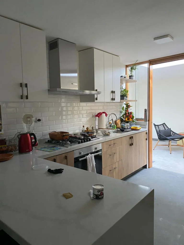 Cocina moderna con mobiliario a medida en melamina, encimera clara y diseño funcional en Arequipa