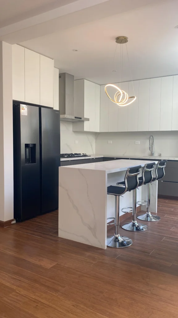 Cocina moderna con isla central y mobiliario a medida en melamina, diseño en Arequipa