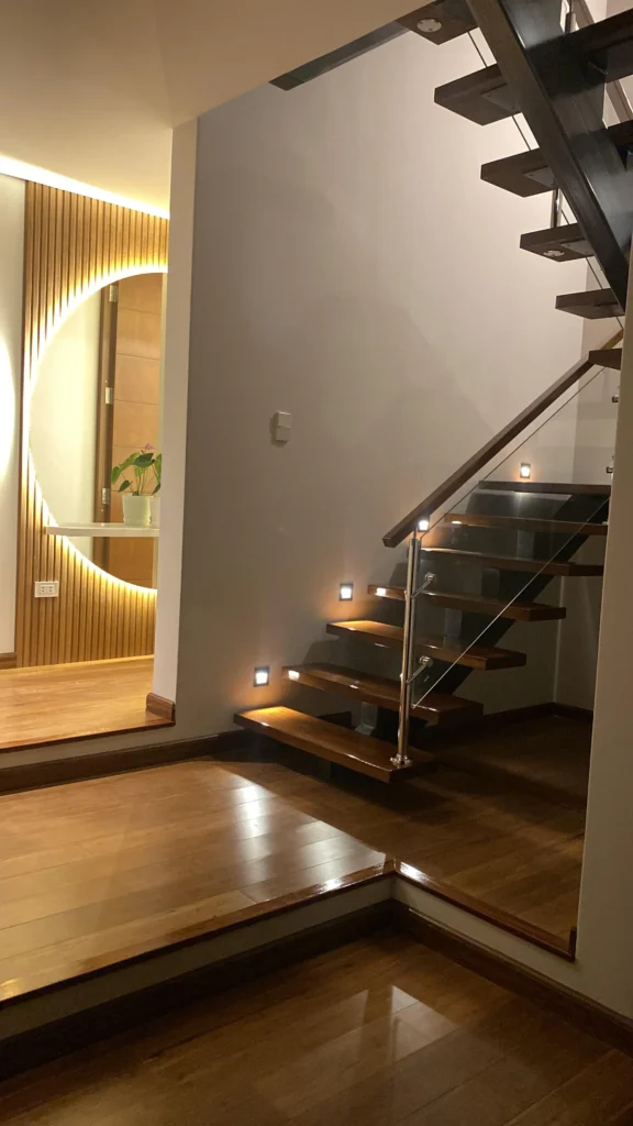 Escalera moderna de madera con iluminación empotrada y diseño interior contemporáneo en Arequipa